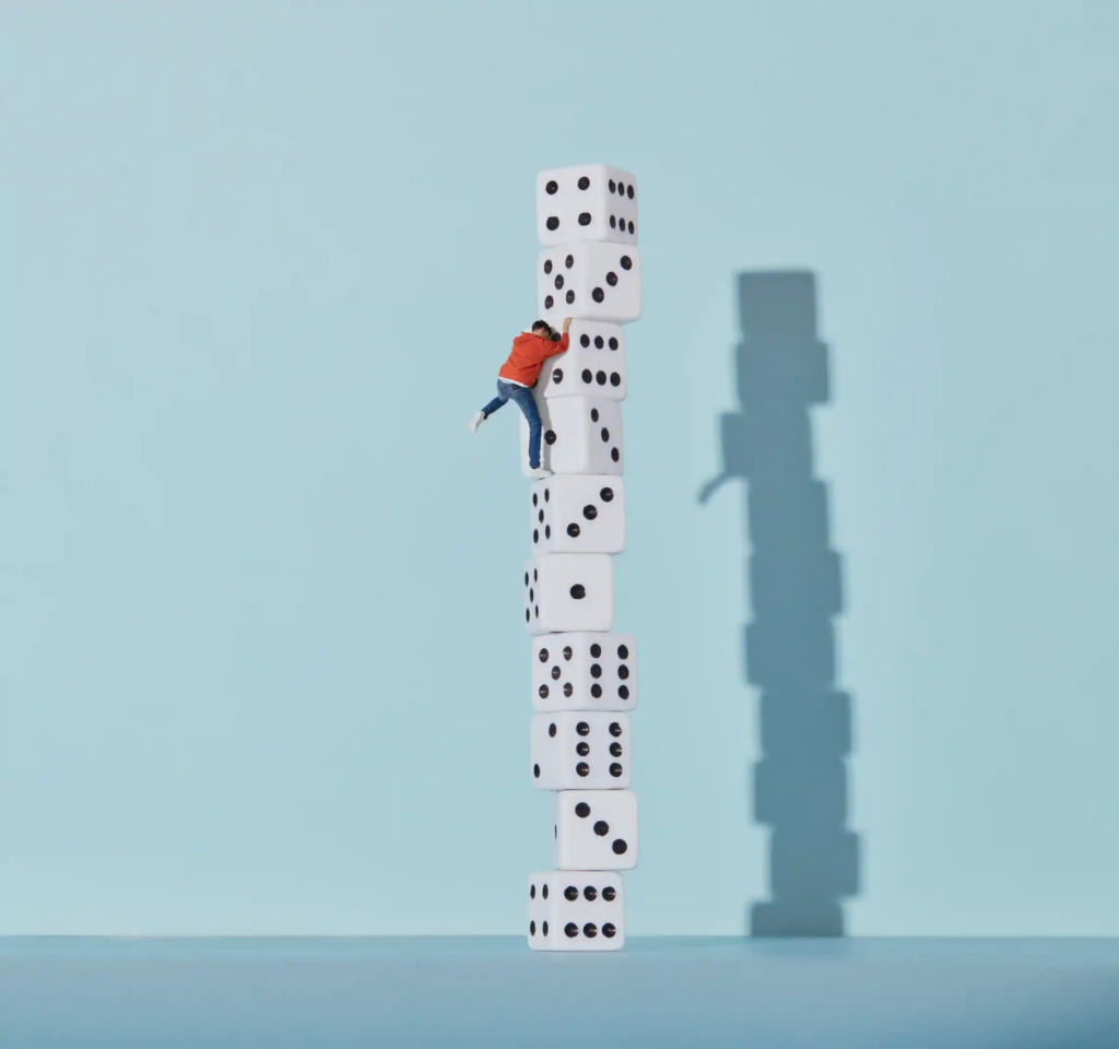 Person climbing up a stack of dice