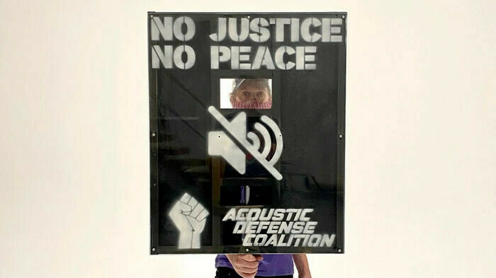 Sign with hole cut out saying 'NO JUSTICE NO PEACE'