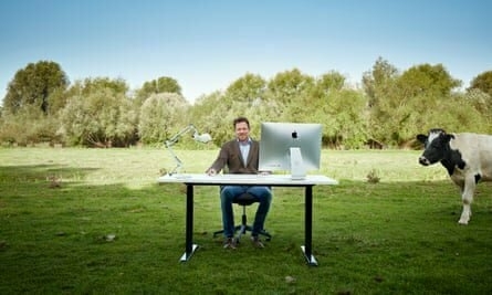 Man in field sitting at desk and computer